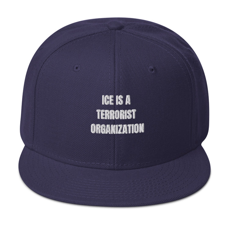Snapback Hat with bold text "ICE IS A TERRORIST ORGANIZATION" in white on navy background.