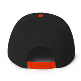 Back view of a Snapback Hat featuring a black body and an orange snap closure for adjustable fit.