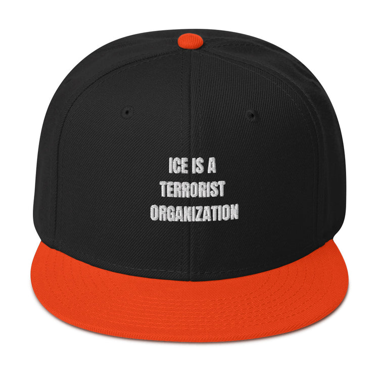 Snapback Hat featuring bold text "ICE IS A TERRORIST ORGANIZATION", black body and orange visor.